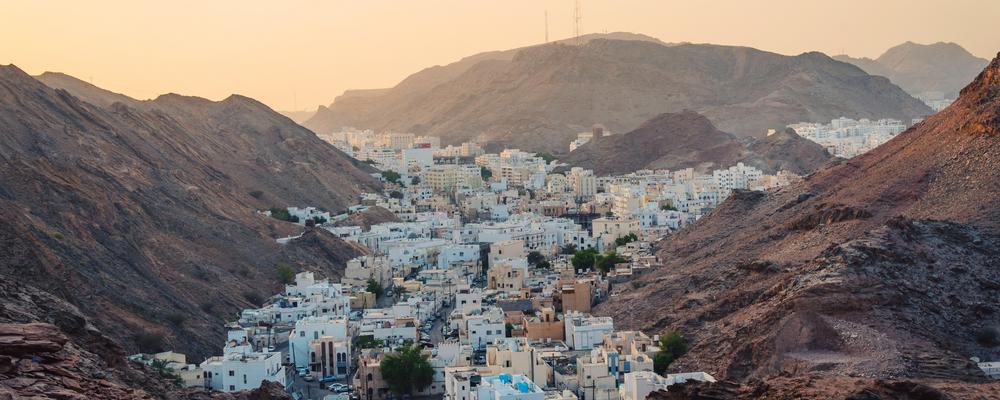 white buildings in a valley against a cream colored sky.