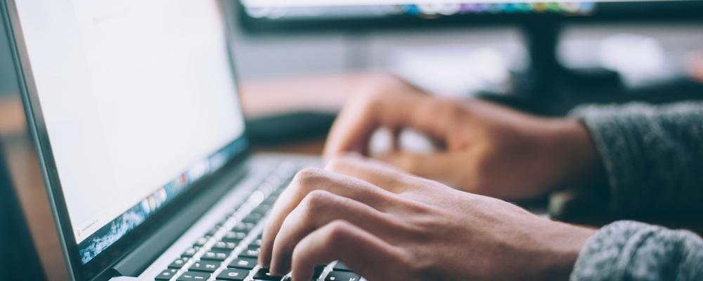 image of hands on laptop keyboard